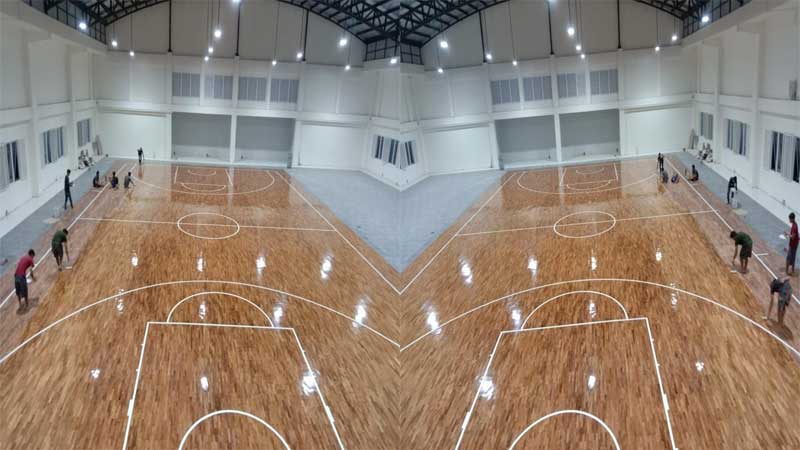 proses finishing lantai kayu pada lapangan basket indoor